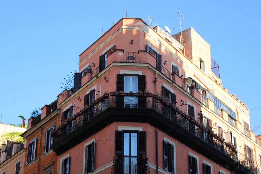 Front low POV of pink corner building.