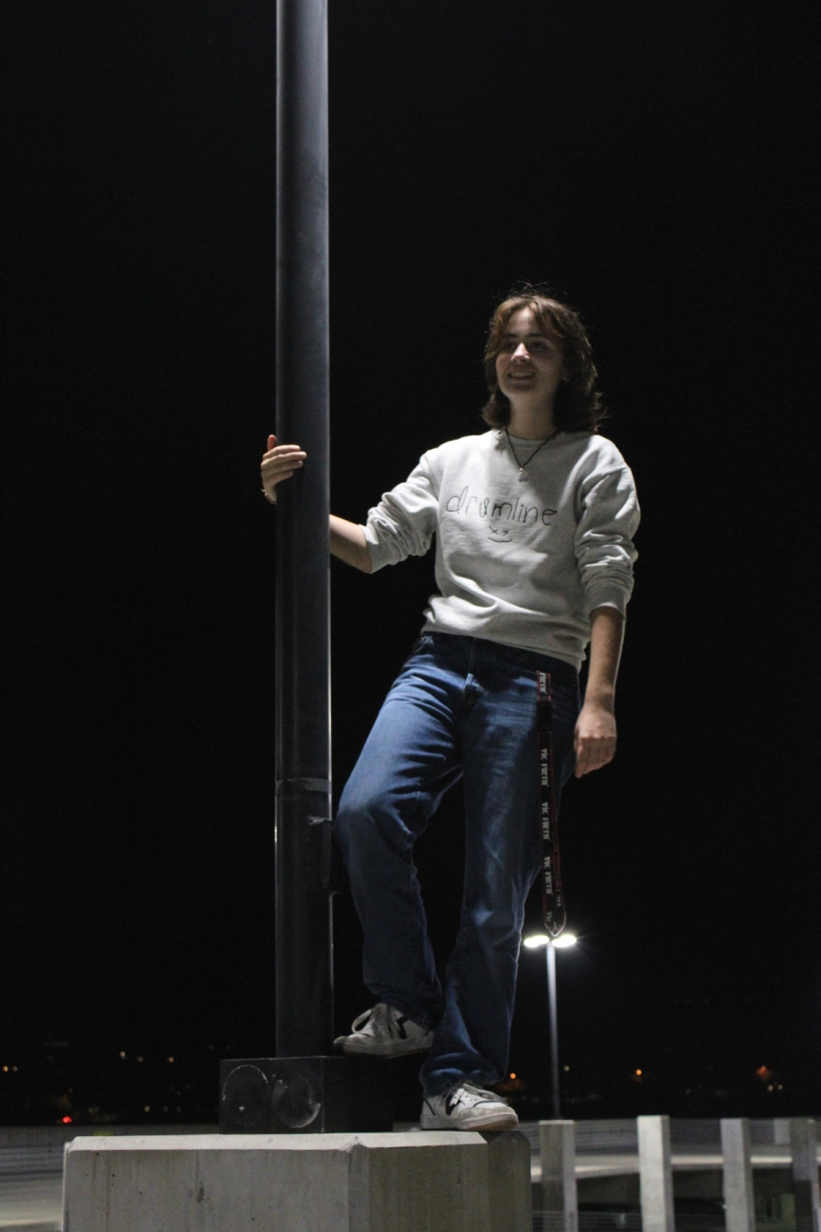 Girl standing and holding lamppost.