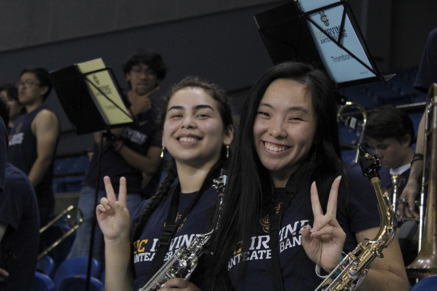 Two alto sax girls hold up peace signs.
