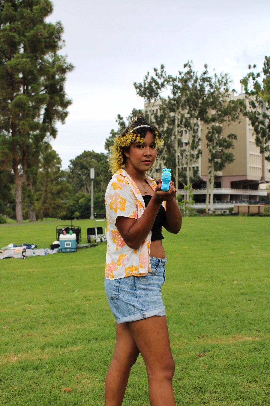 Girl pointing water gun at camera.