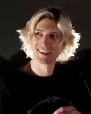 xQc (Félix Lengyel) smiling with his blond hair lit from behind, July 2023