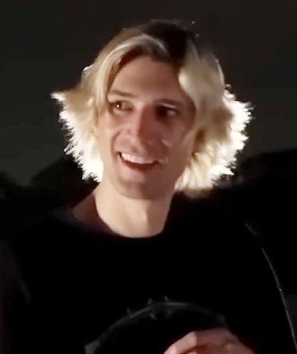 xQc (Félix Lengyel) smiling with his blond hair lit from behind, July 2023