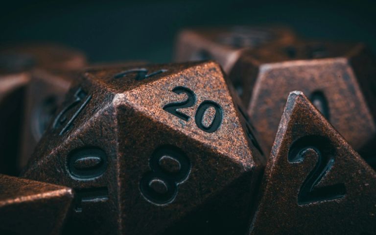 Metal gaming dice on a table — the planning side of RPG theorycrafting