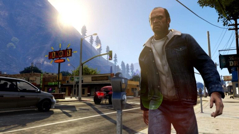 A man in a denim jacket stands on a sunny street in a small town.