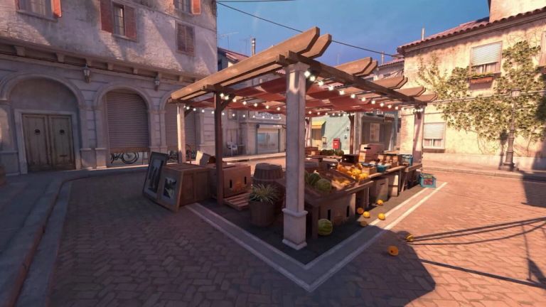 Counter-Strike 2: A fruit stall under a wooden canopy in a sunlit stone town square.