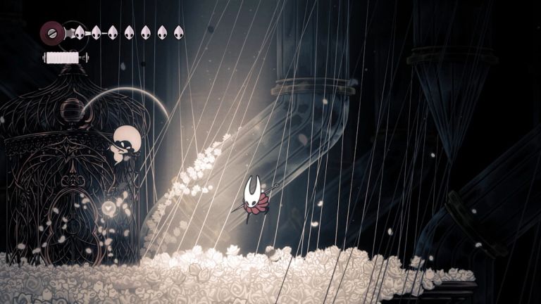 Hollow Knight: Silksong — Hornet descends among hanging strands over a carpet of pale flowers.