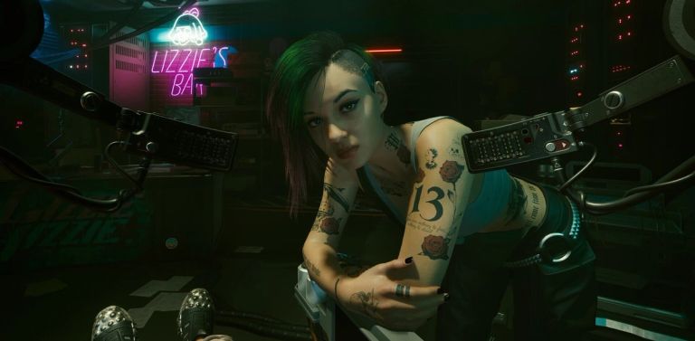 A tattooed woman with a short haircut leans forward in a neon-lit club.