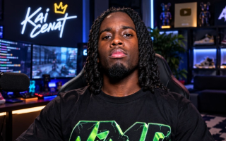 AI-generated image of Kai Cenat with long locs in a black AMP T-shirt, sitting at his neon-lit streaming setup
