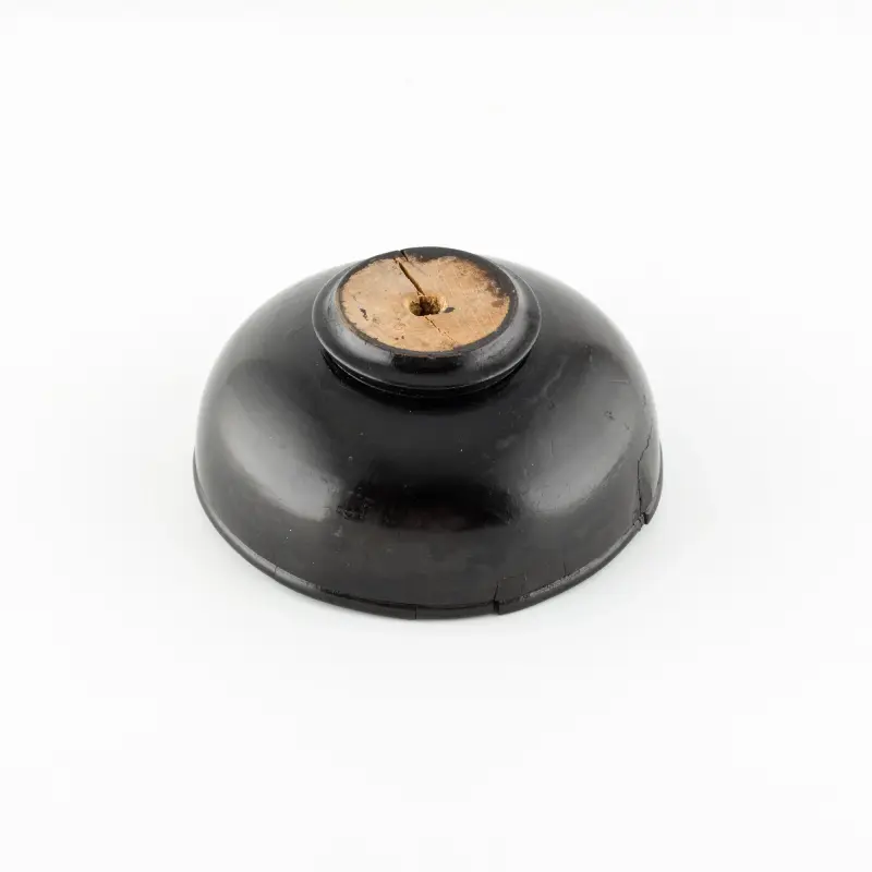 Feketére festett, tál alakú levélnehezék, benne bronzpénz-utánzatokkal