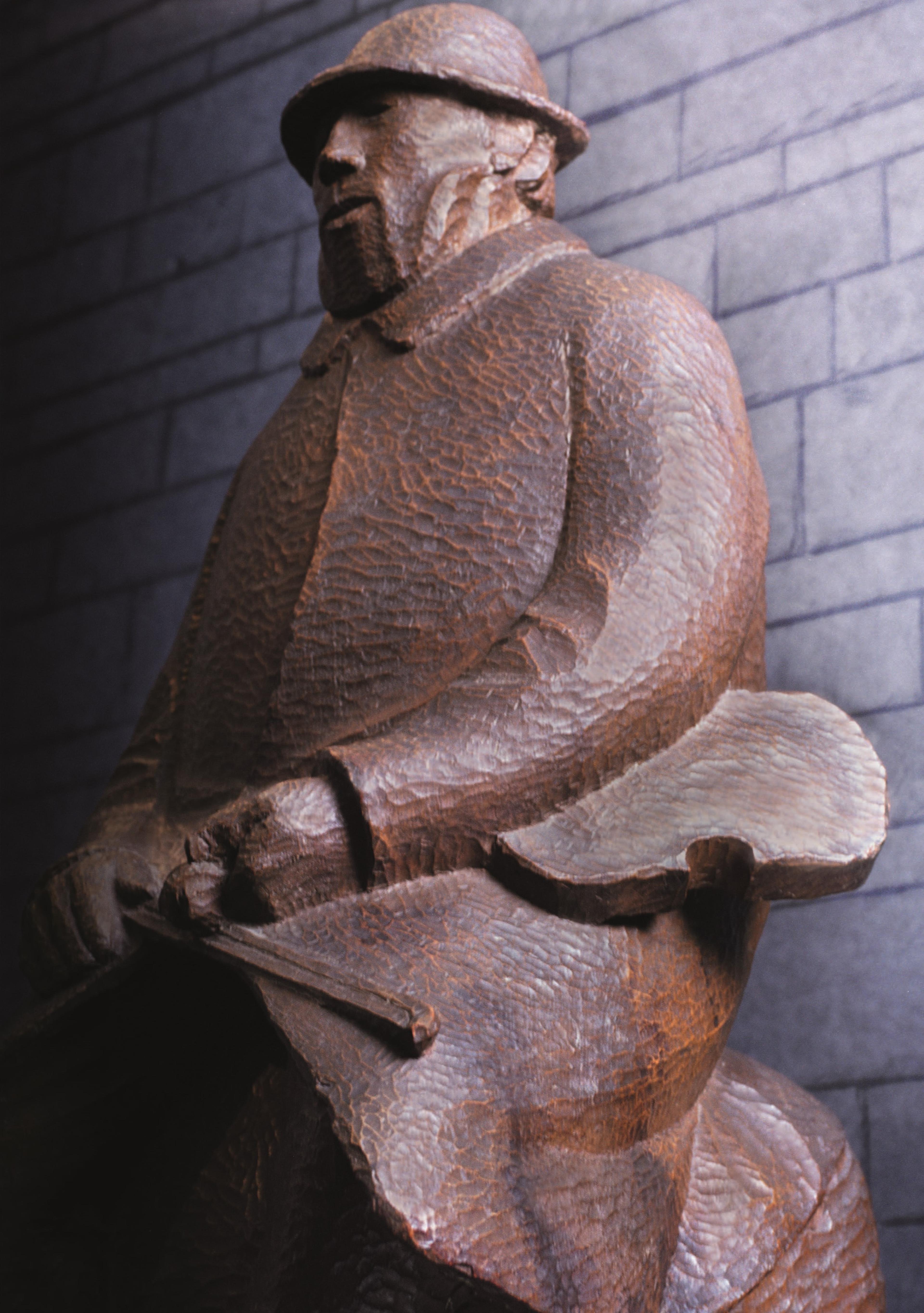 Holzskulptur eines sitzenden Mannes mit Geige