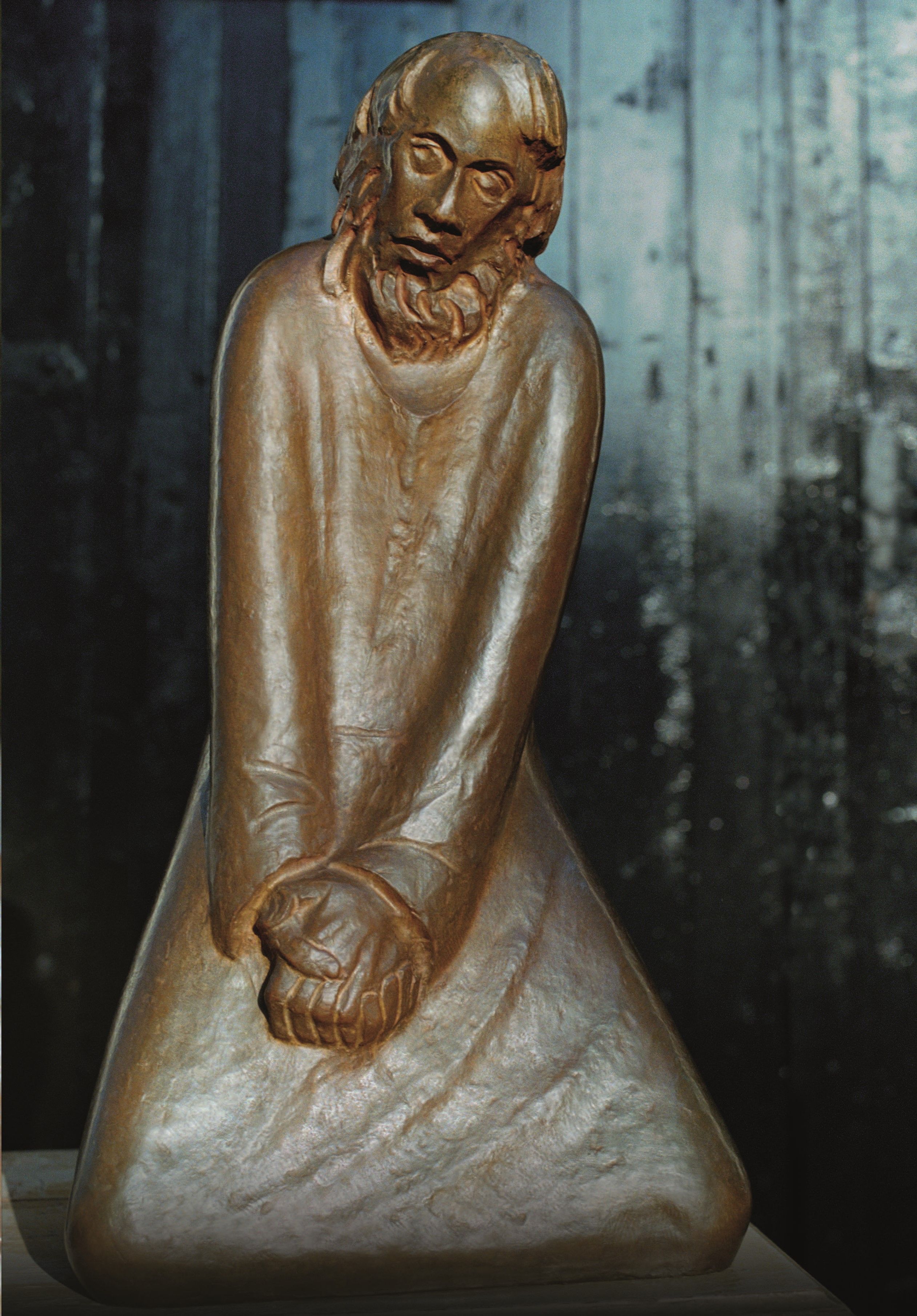 Ein knieender Mann mit gefalteten Händen