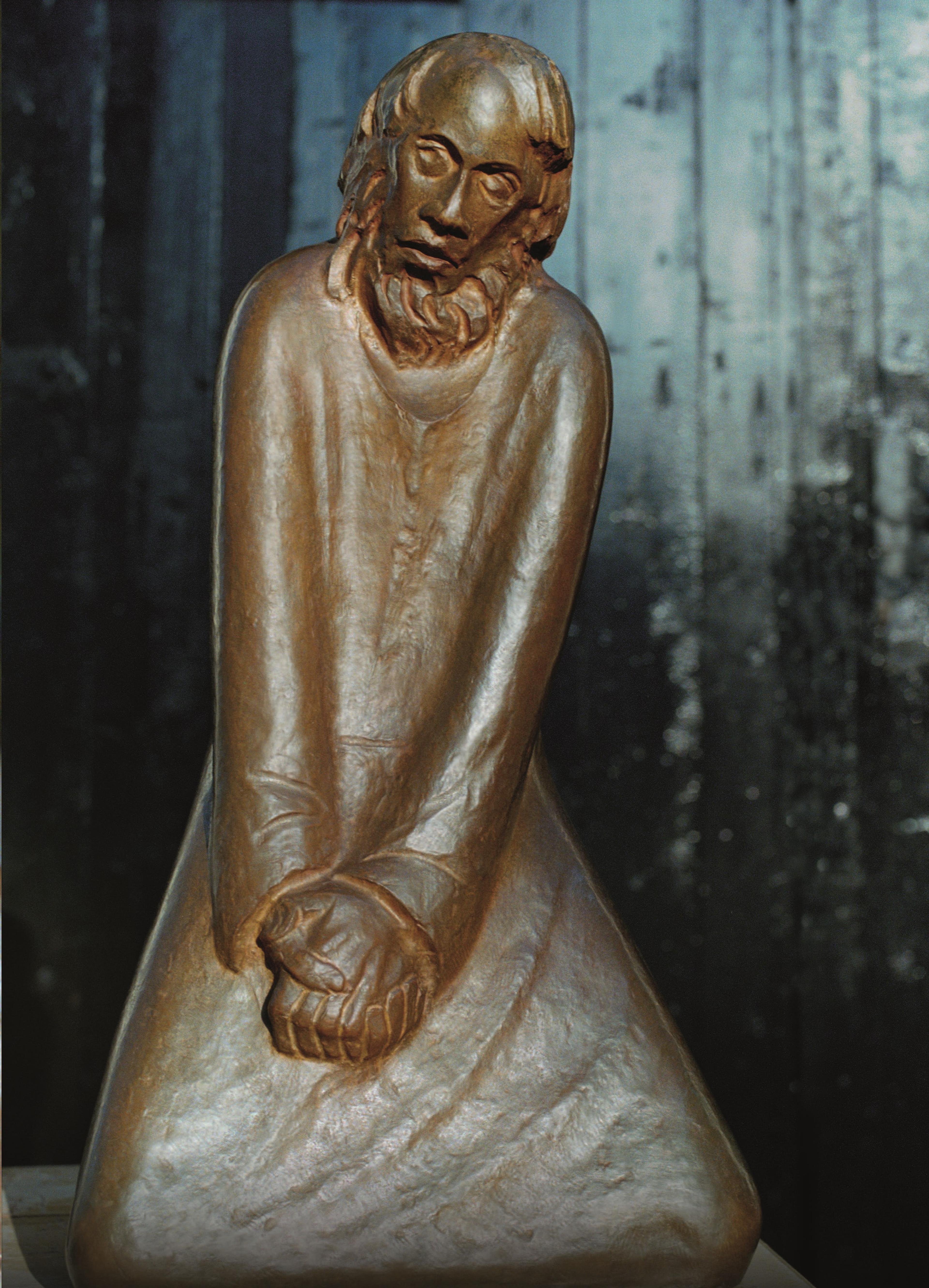 Ein knieender Mann mit gefalteten Händen