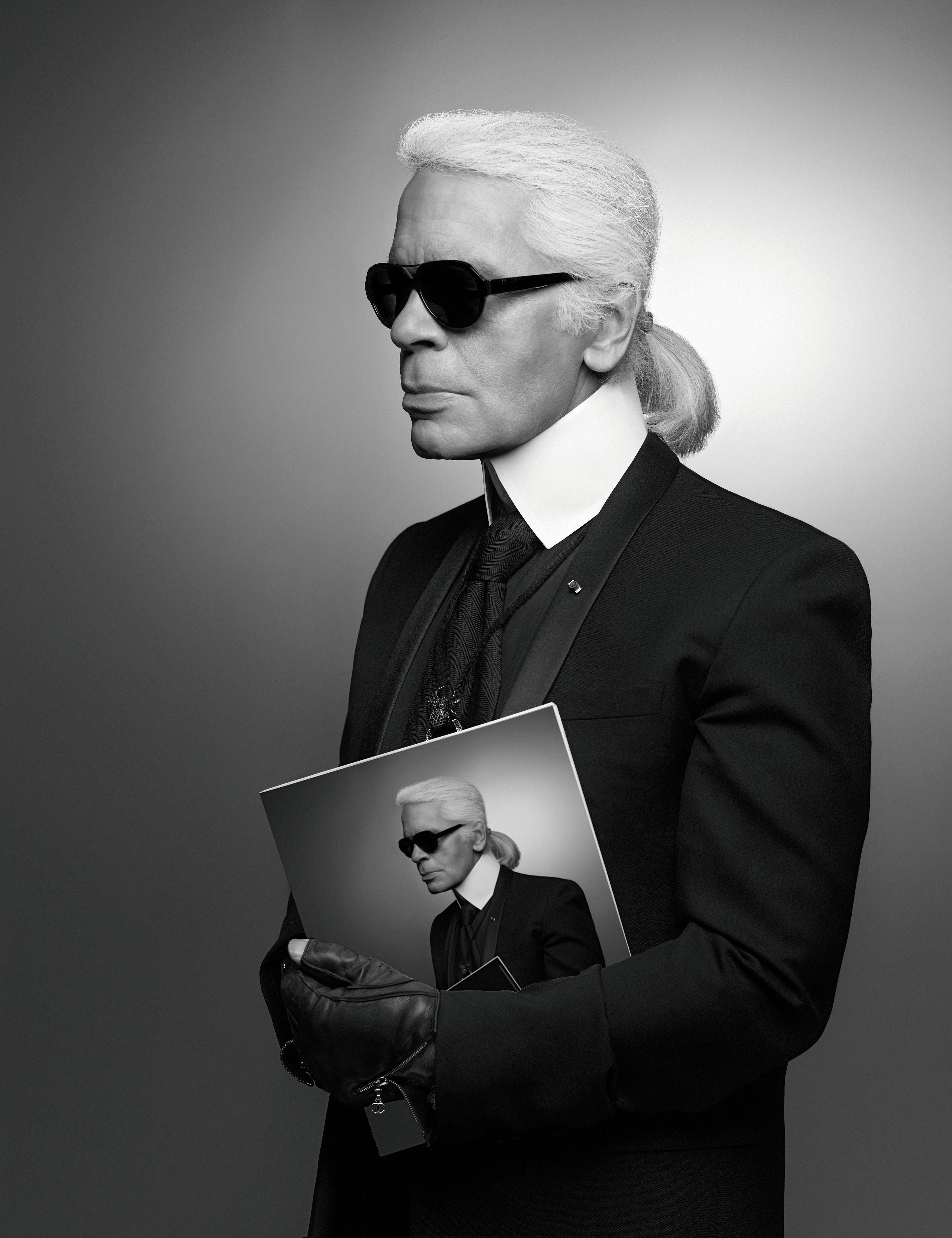 Karl Lagerfeld im Profil trägt eine Karte mit seinem Selbstportrait
