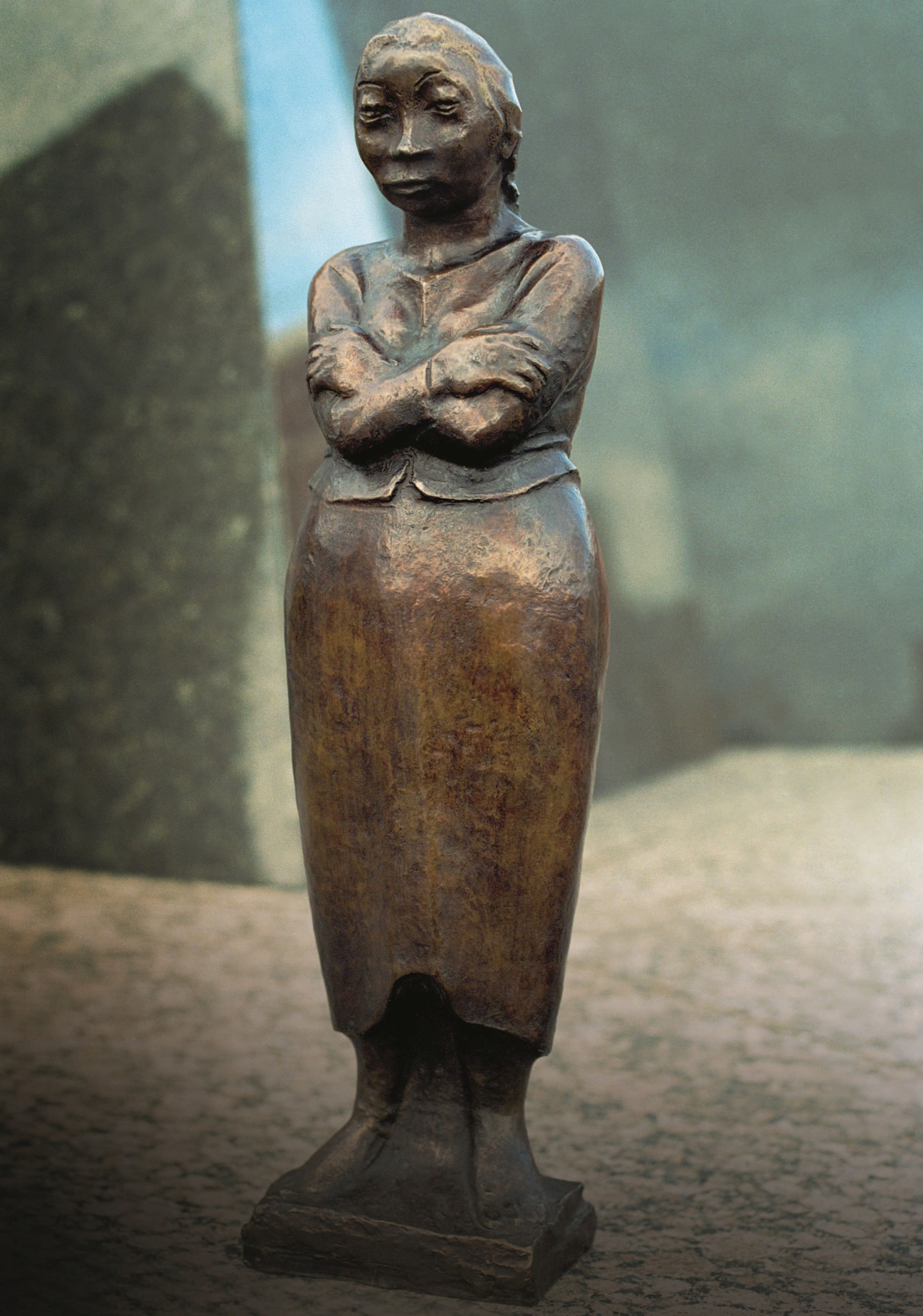 Skulptur einer Frau mit verschränkten Armen