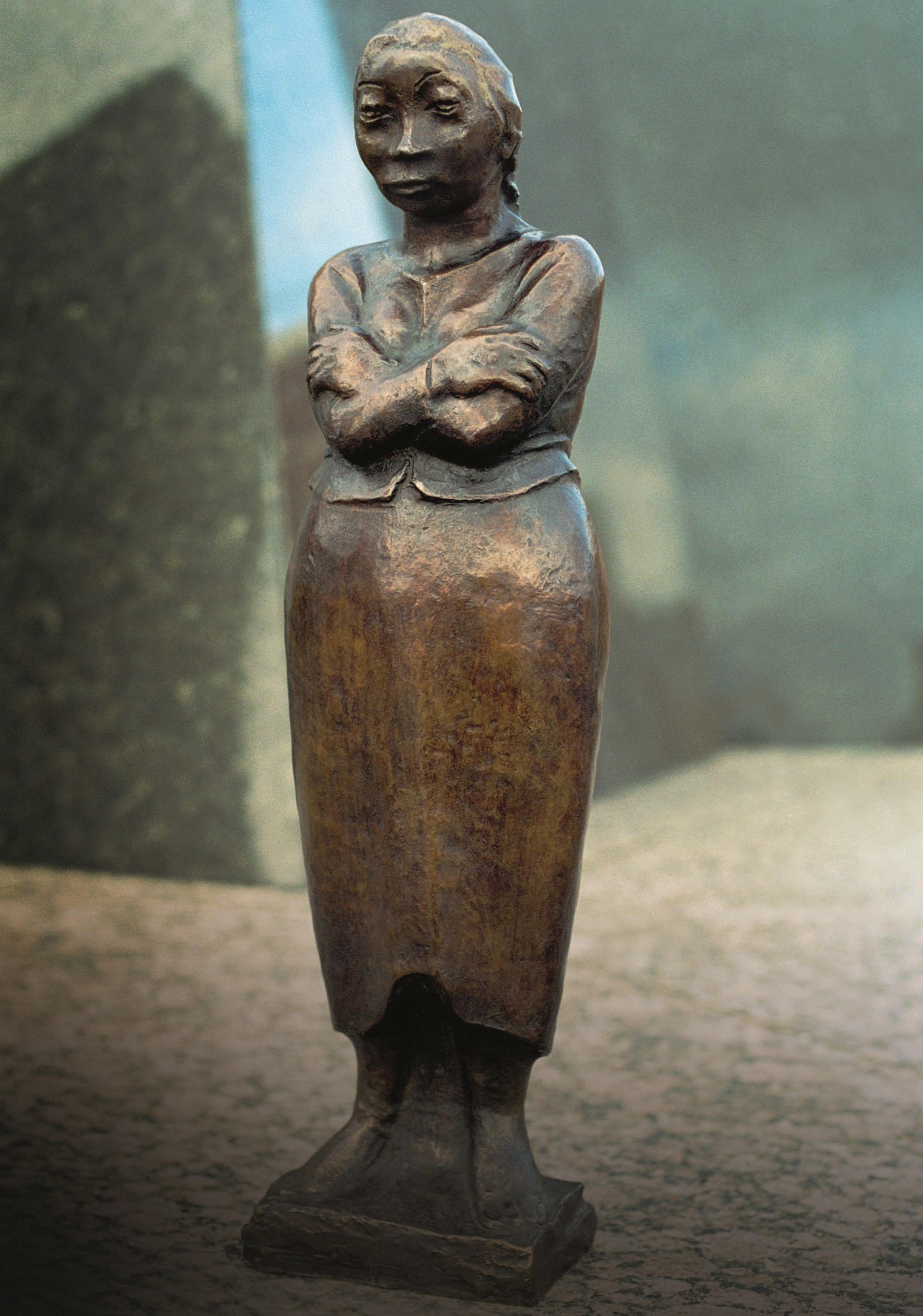 Skulptur einer Frau mit verschränkten Armen