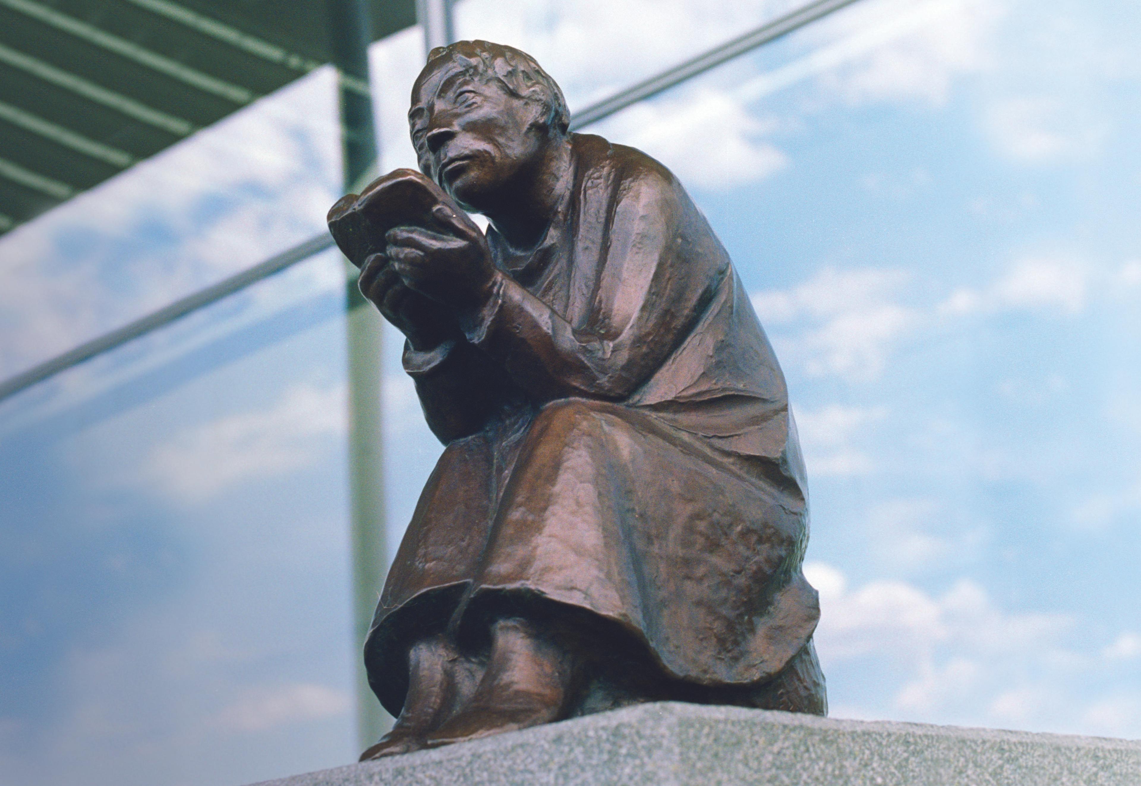 Figur eines Mannes mit Buch in den Händen