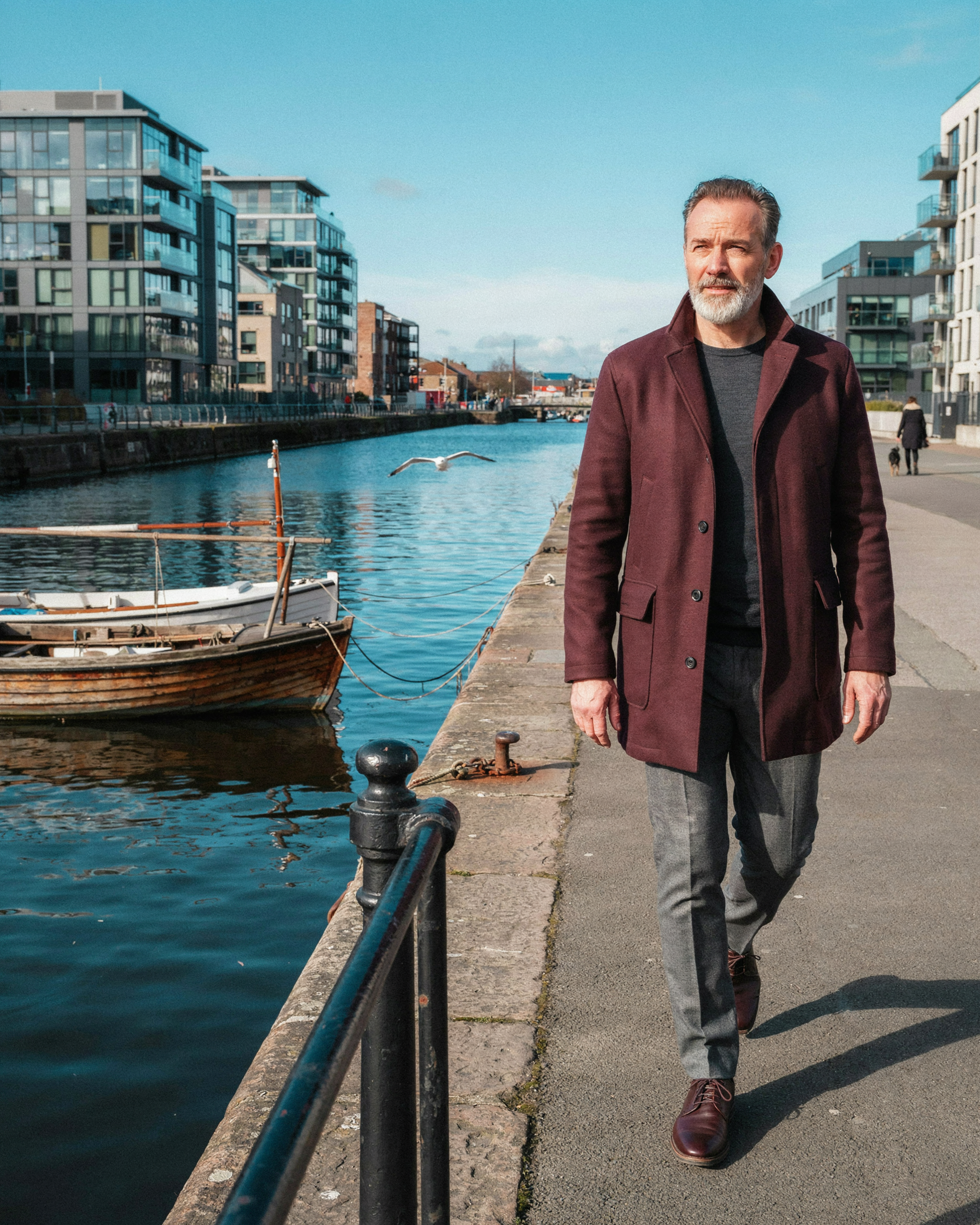 Adult walking along the Leith waterfront in Edinburgh, relaxed and energetic while managing their own care