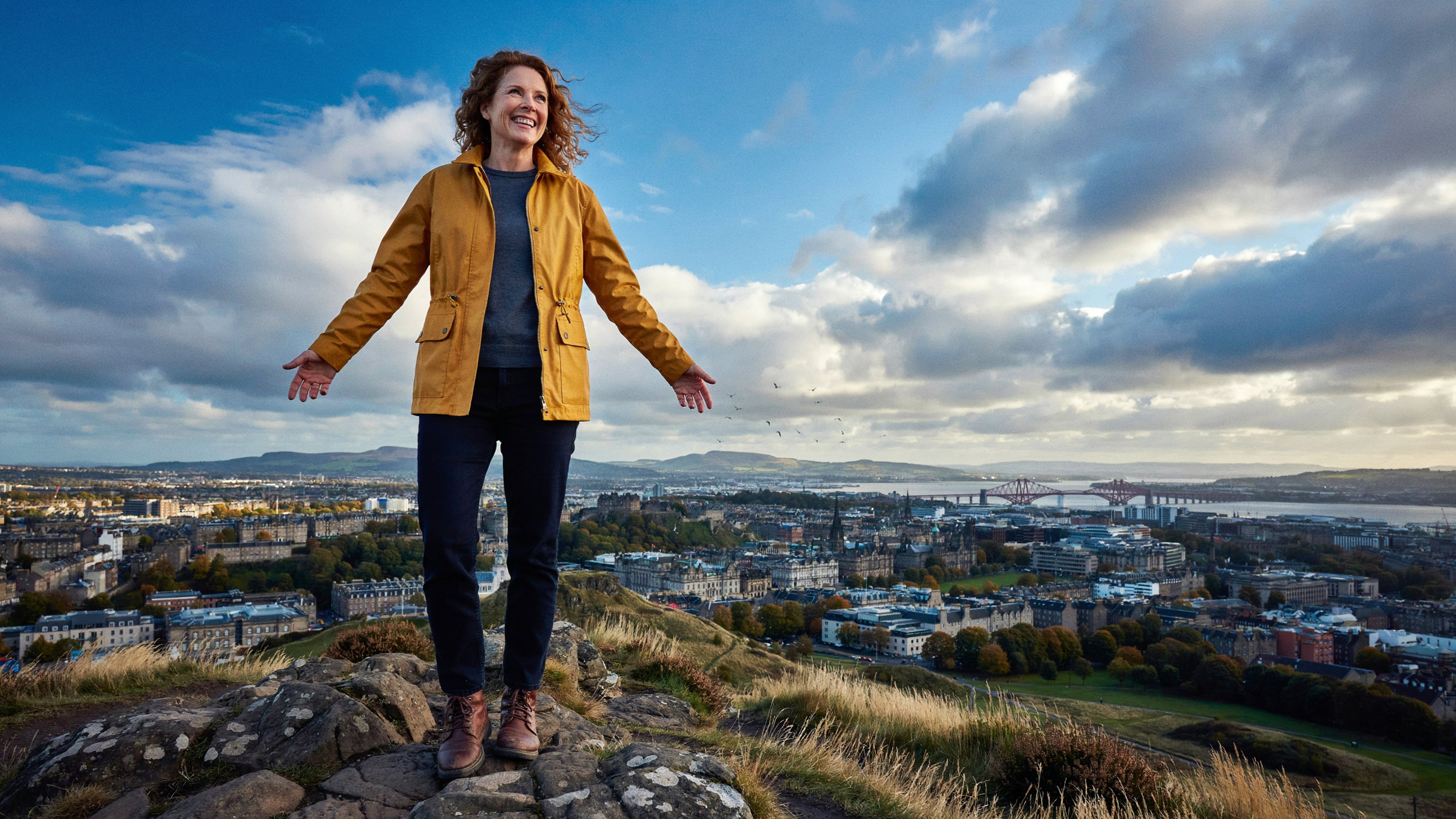 Adult at the summit of Arthur's Seat in Edinburgh, healthy and strong after months of weight management
