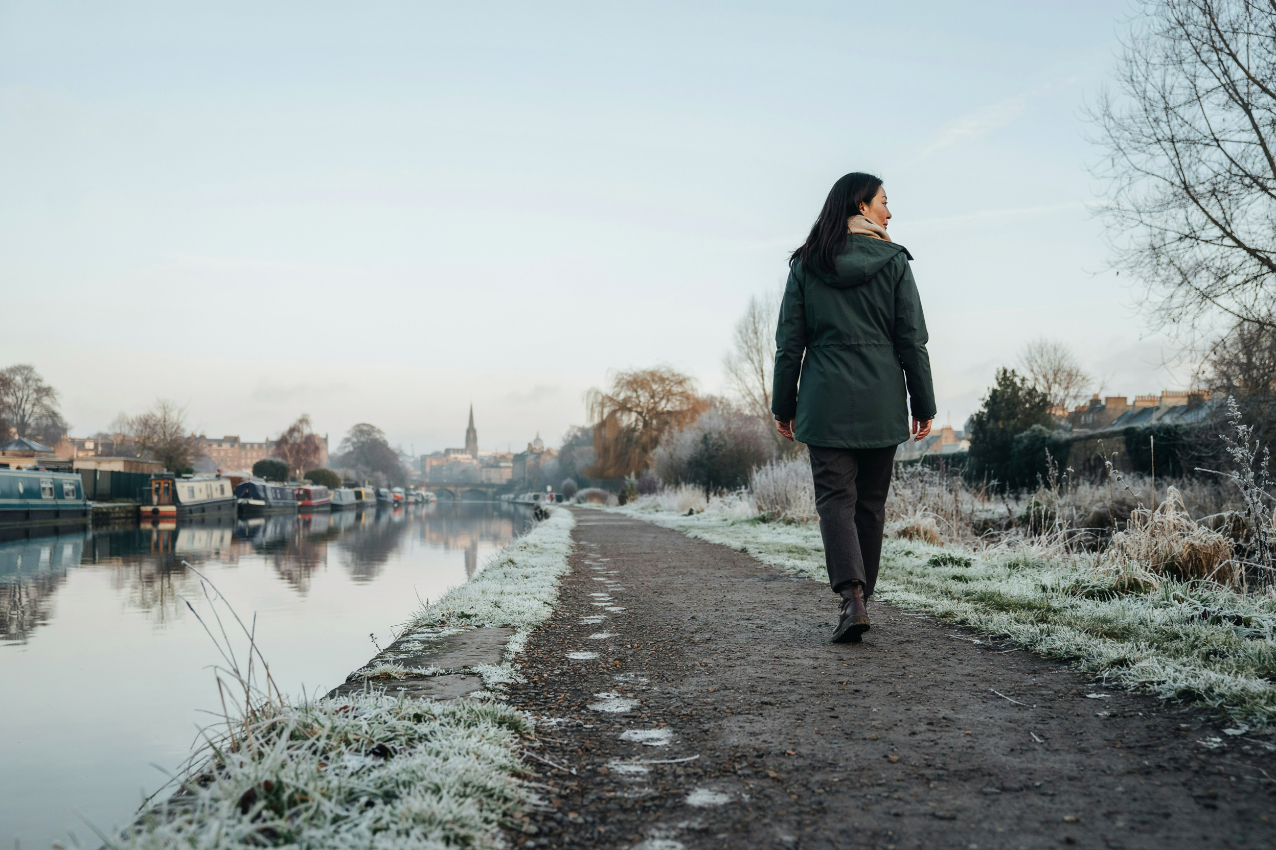 Adult walking the Union Canal towpath in Edinburgh on a frosty morning, someone with a long-term condition staying well over winter