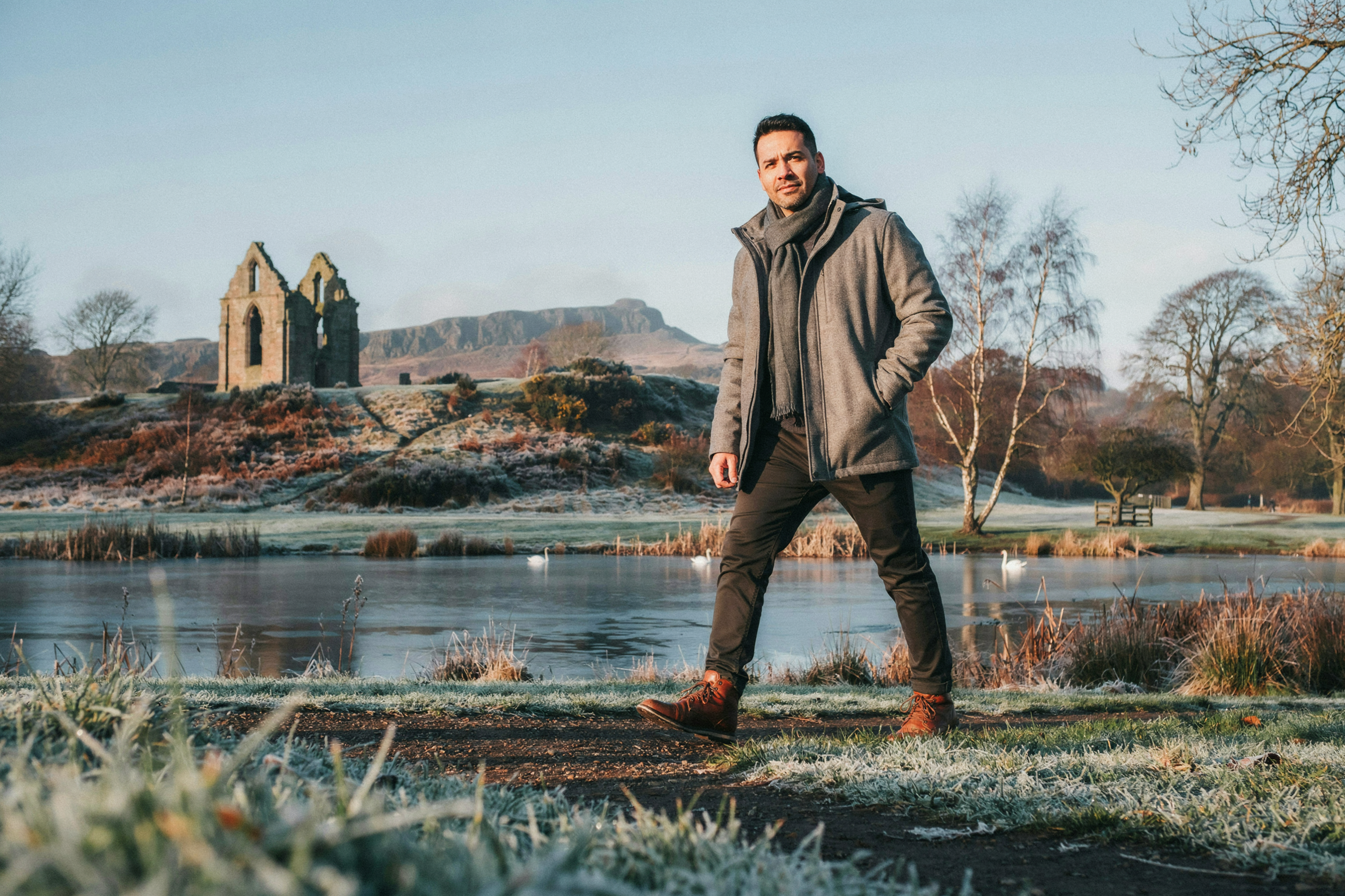 Adult beside St Margaret's Loch in Holyrood Park, Edinburgh, on a winter afternoon, reassured after sorting out a private COVID-19 vaccine