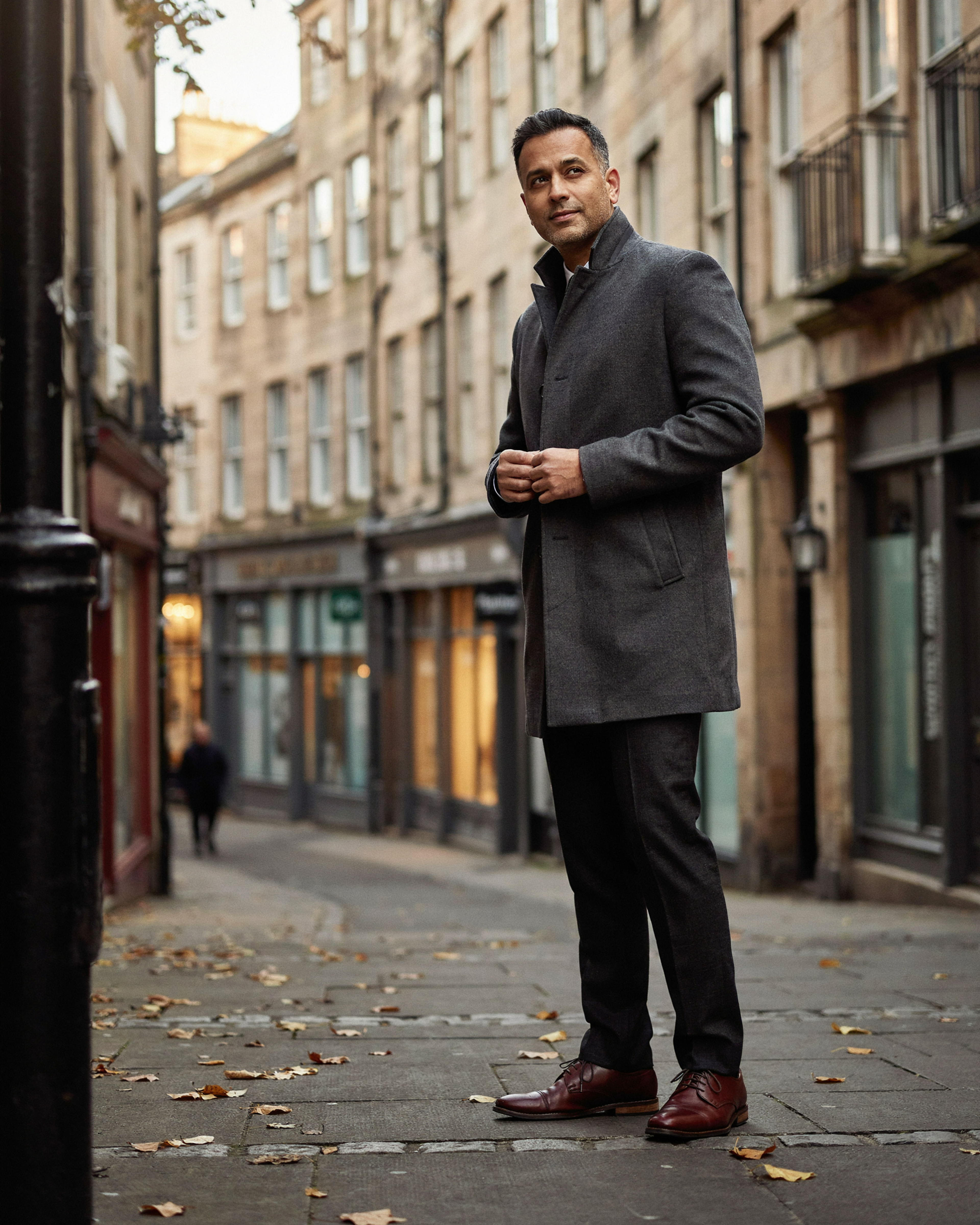 Adult stepping out onto a sunny Edinburgh street after a private flu jab appointment at a local pharmacy