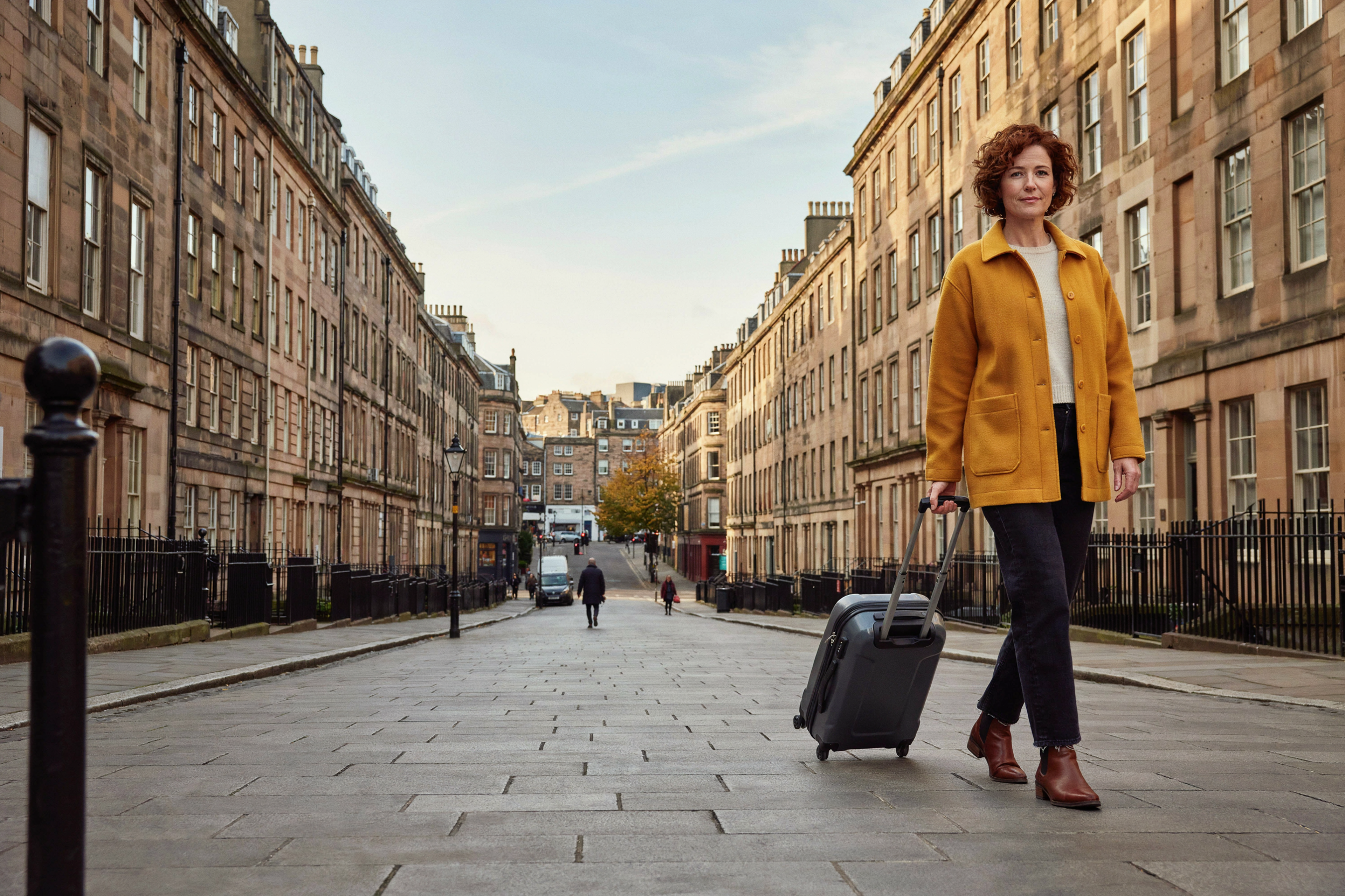 Adult setting off on a trip from Edinburgh's New Town with a small suitcase, having timed their COVID-19 vaccine two weeks before travel