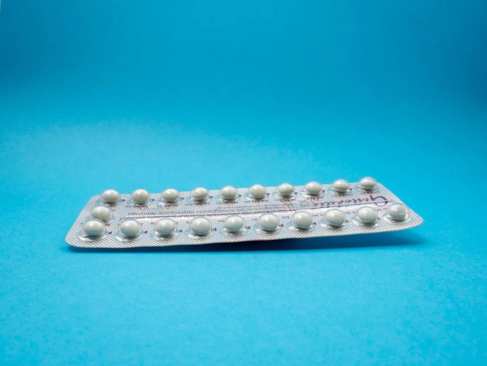 oral contraceptive pill on blue panel