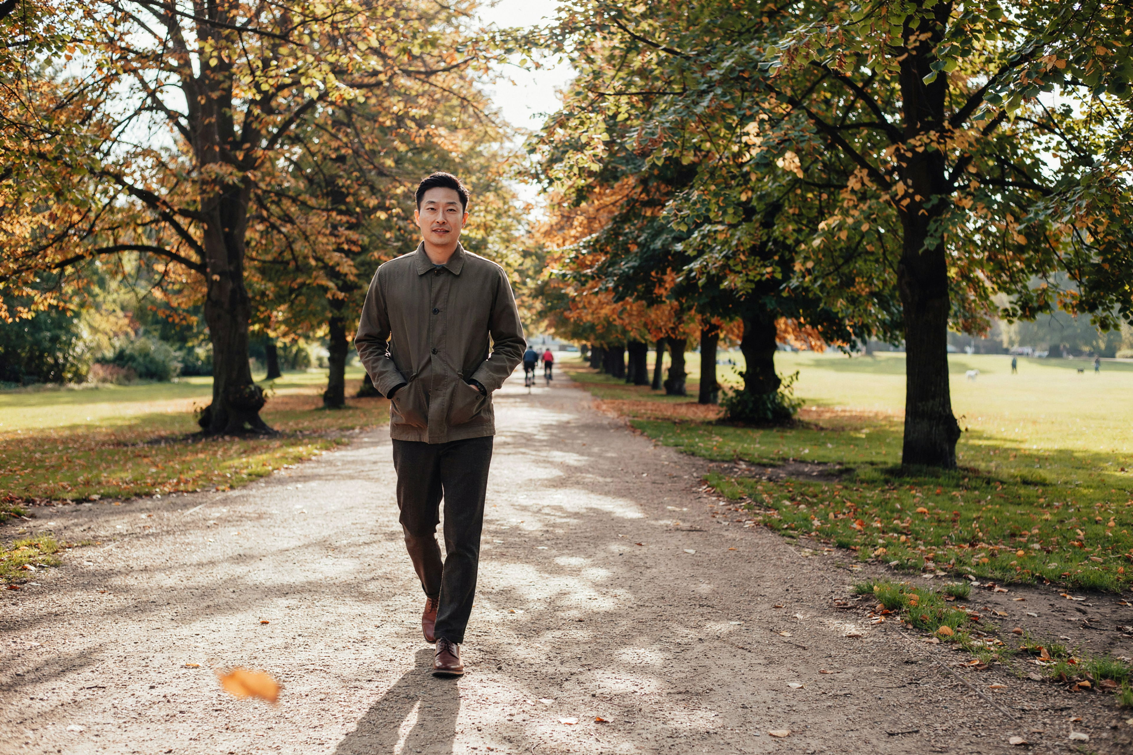 Adult walking under autumn trees in the Meadows, Edinburgh, protected for the winter ahead by a yearly flu vaccine