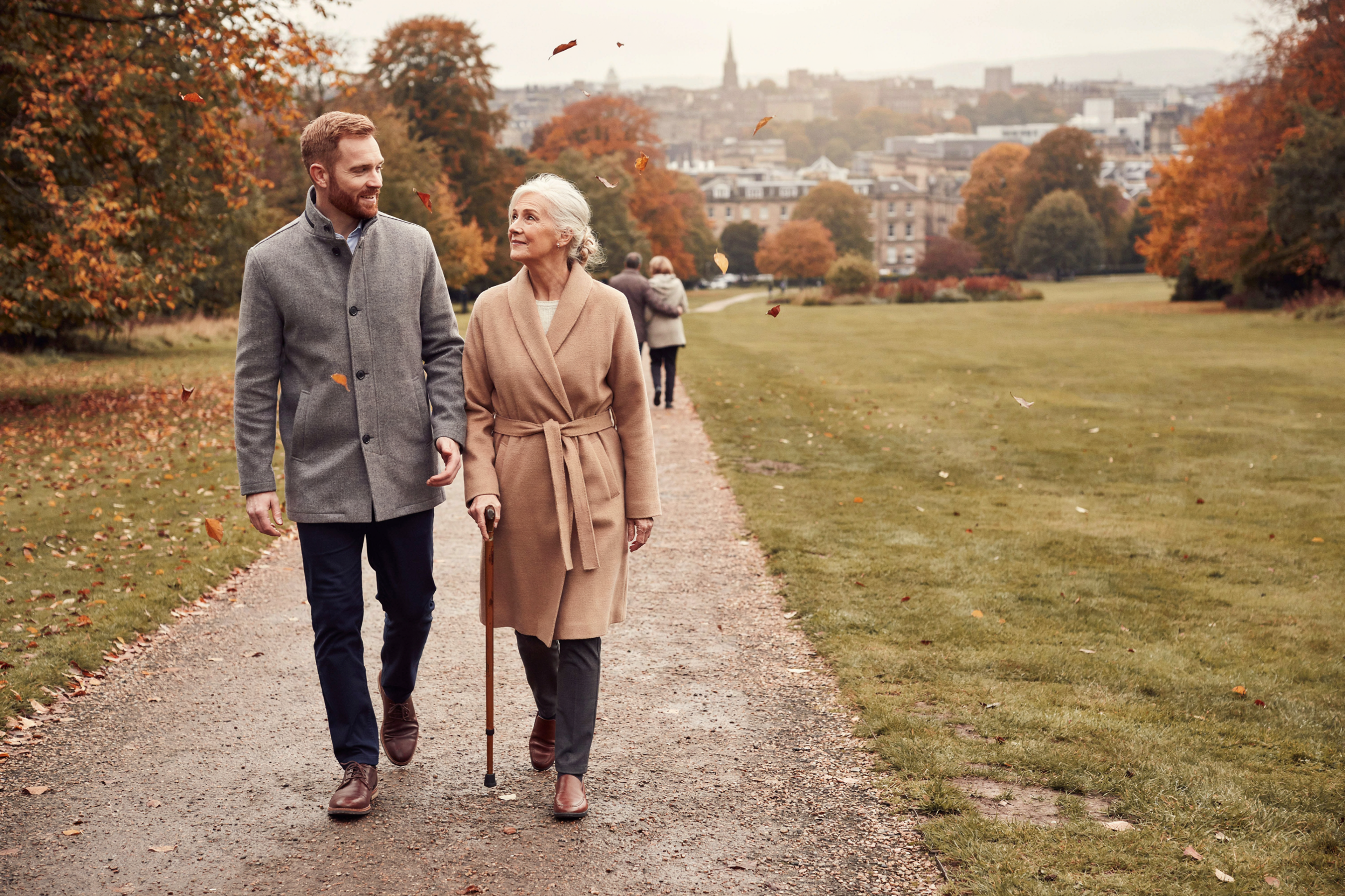 Adult walking with their mother, aged over 75, in the Royal Botanic Garden Edinburgh, one of the groups offered a free NHS COVID-19 vaccine in Scotland