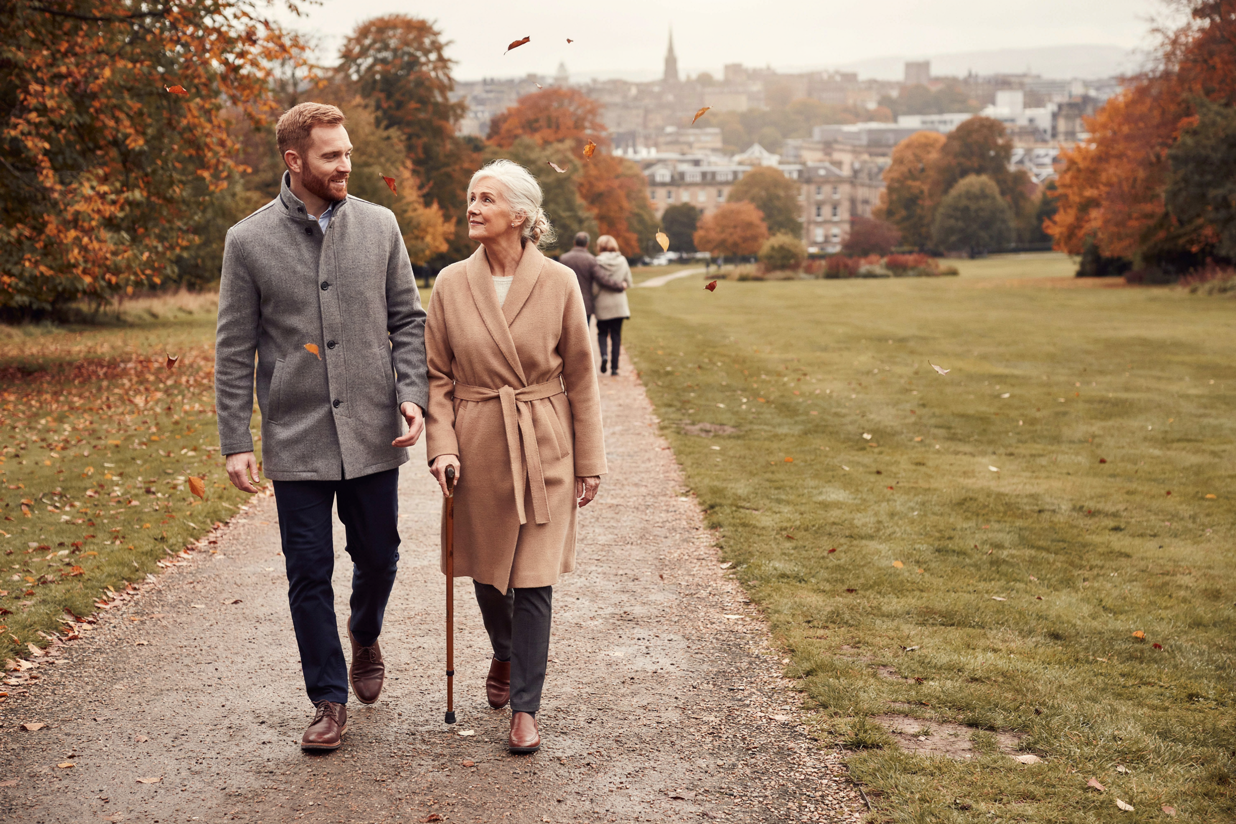 Adult walking with their mother, aged over 75, in the Royal Botanic Garden Edinburgh, one of the groups offered a free NHS COVID-19 vaccine in Scotland