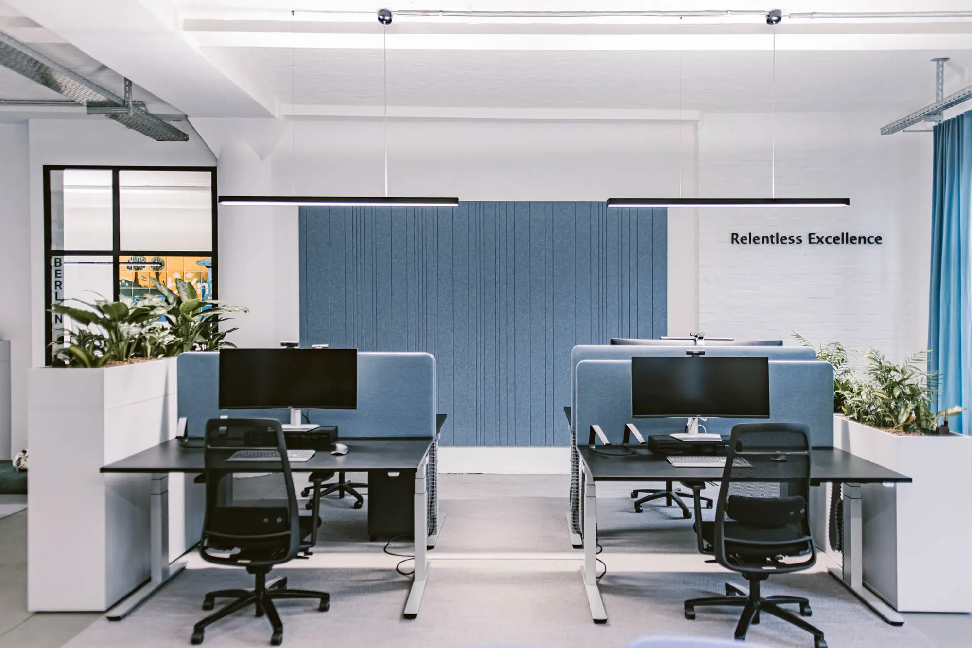 Arbeitsplätze mit blauen Akustikelementen und moderner Beleuchtung