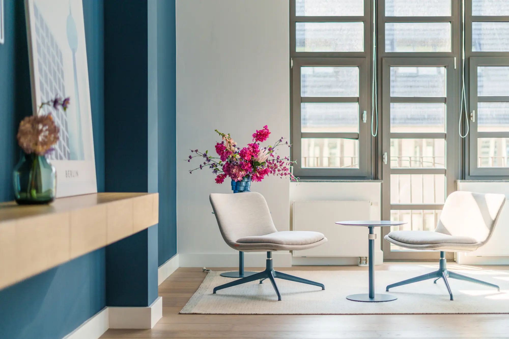 Loungestühle im lichtdurchfluteten Empfangsbereich mit Blumen in einem Berliner Office