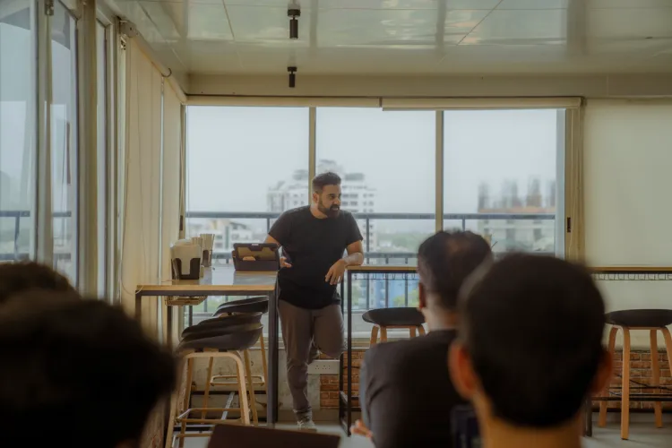 a man is giving a presentation to a group of people in a room .