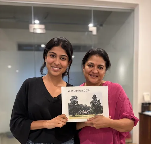 Two smiling women hold a book titled "Veer Attikan 2016" with a house on its cover.