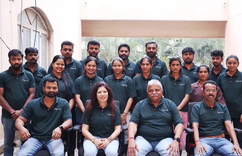 Team photo of 20 people in matching green shirts.