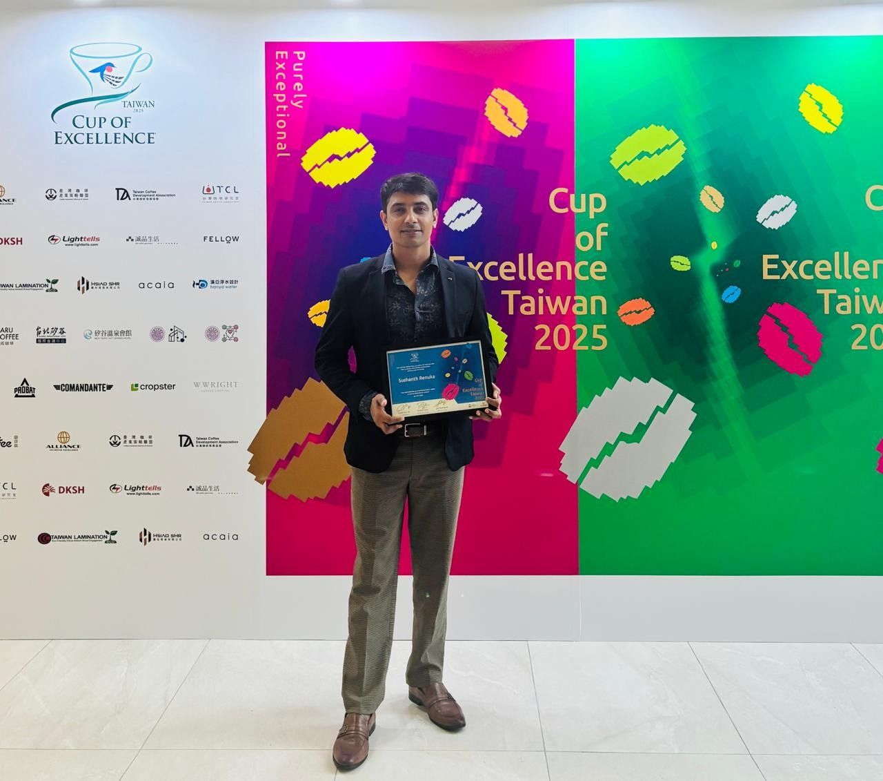 A man holds an award plaque in front of a "Cup of Excellence Taiwan 2025" event backdrop.