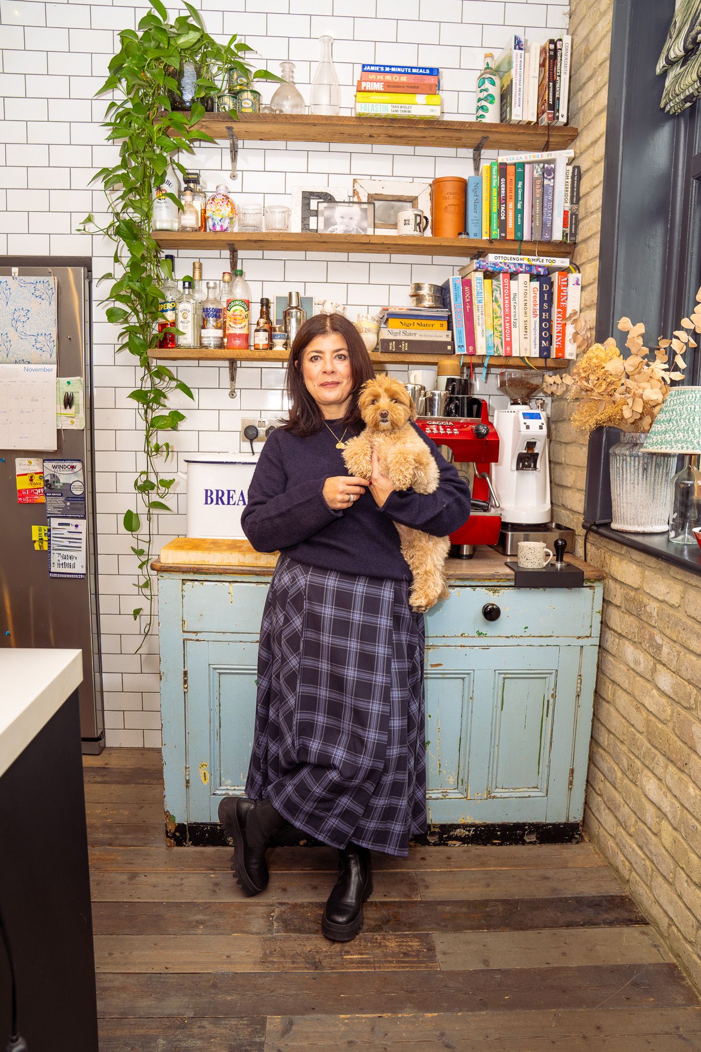 Woman holding a small dog in a kitchen