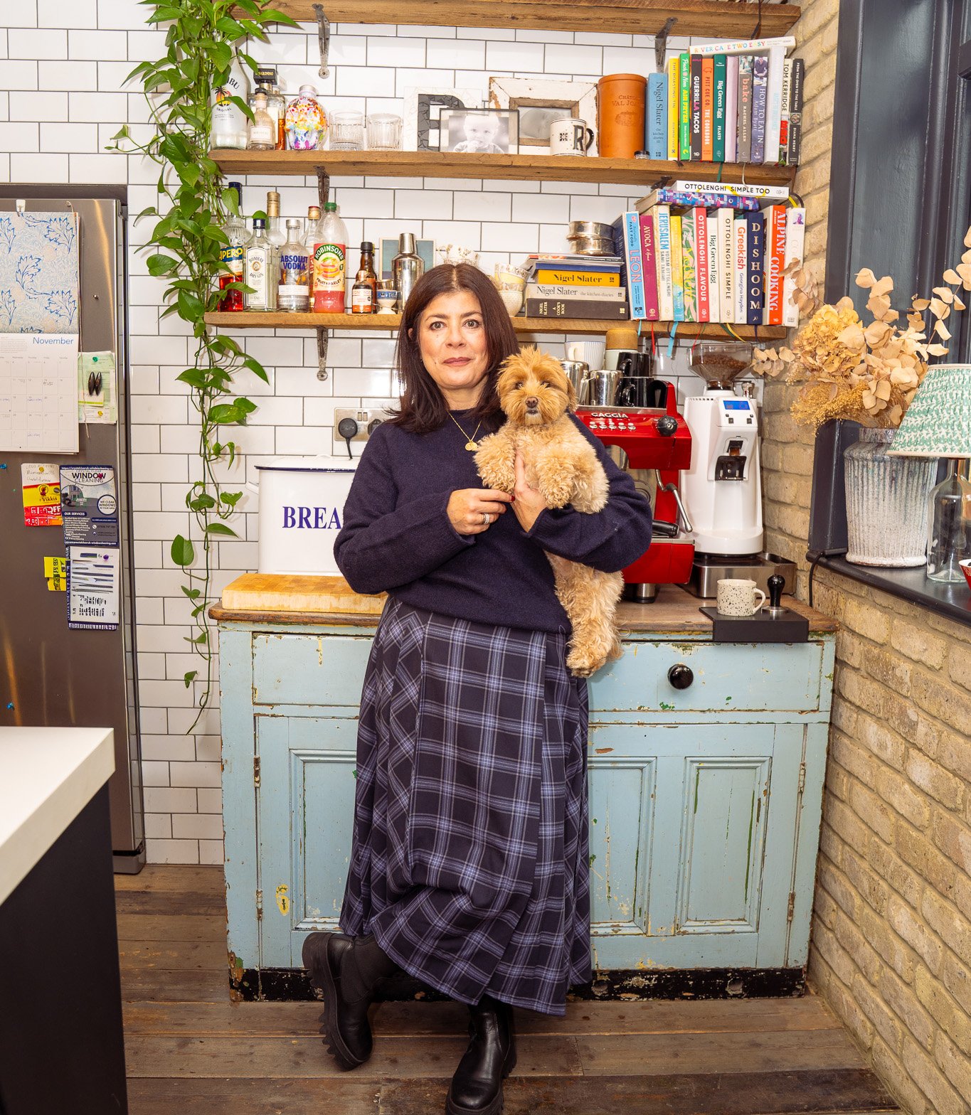 Woman holding a small dog in a kitchen