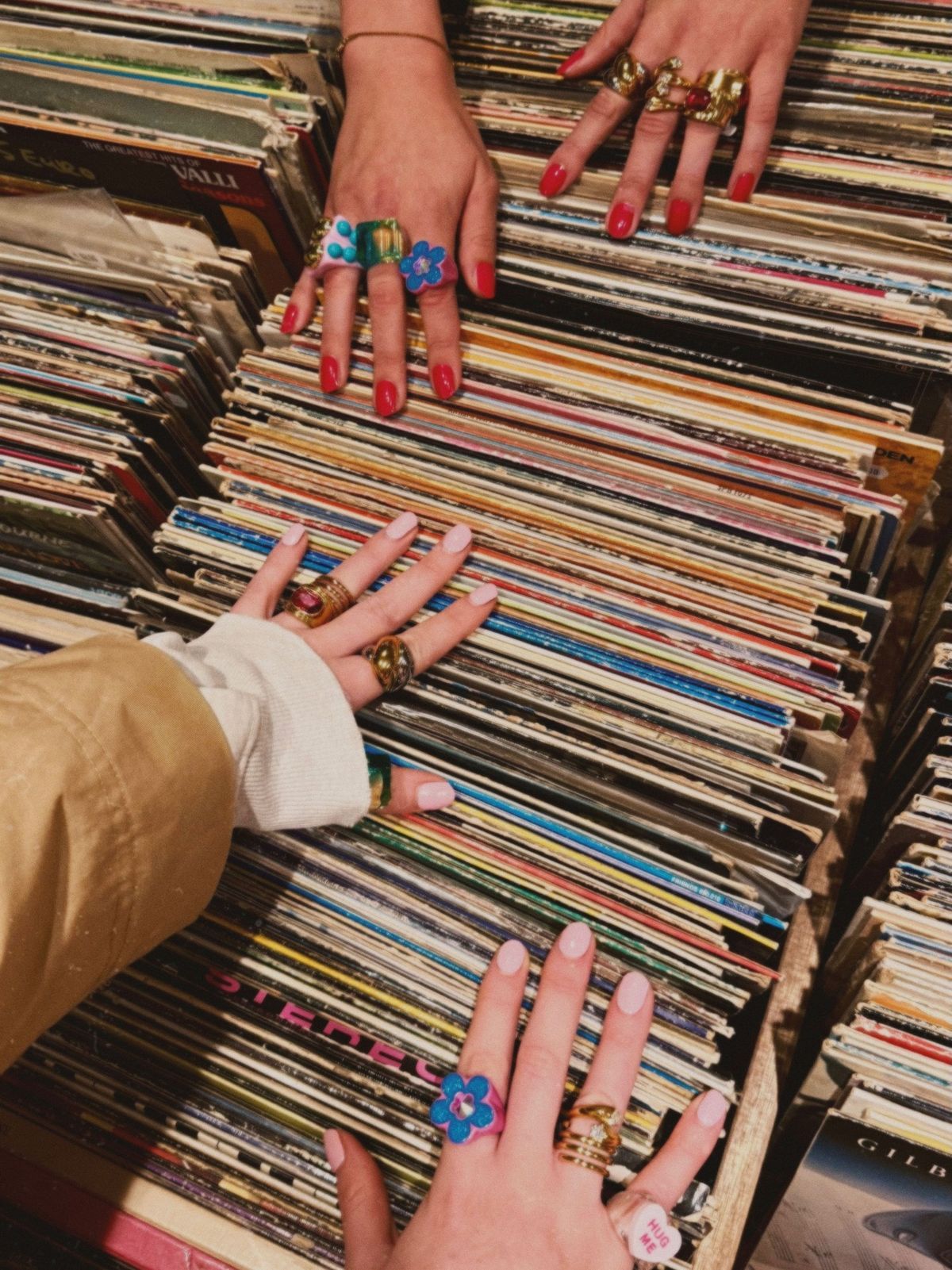 Ringed hands browse rows of vinyl records