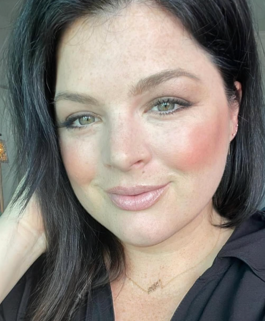 Woman with dark hair smiling at the camera