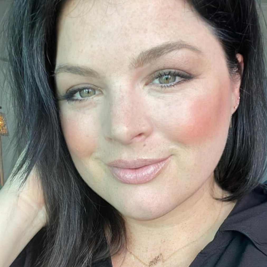 Woman with dark hair smiling at the camera