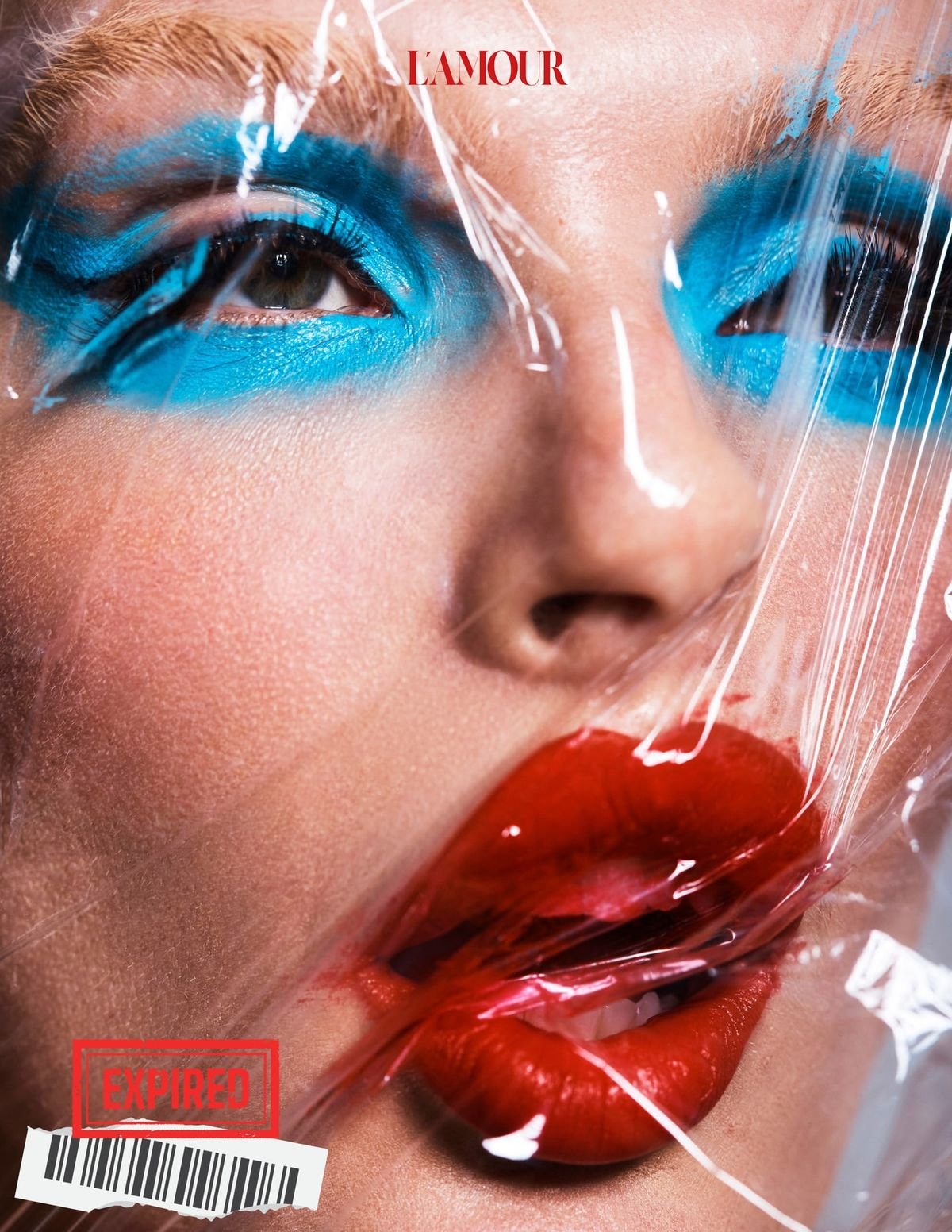 Face with blue eye makeup and red lips behind plastic