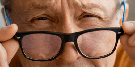 Persona mayor leyendo con dificultad por degeneración macular