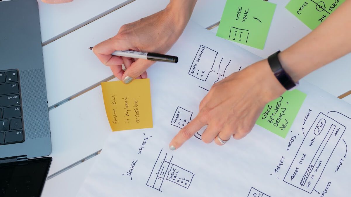 A designer reviews website accessibility sketches and notes.