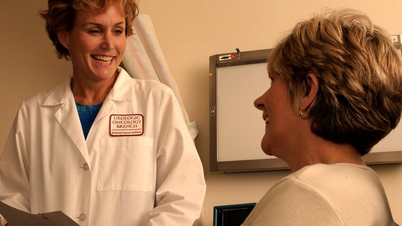 A doctor talks with a patient in a consultation room
