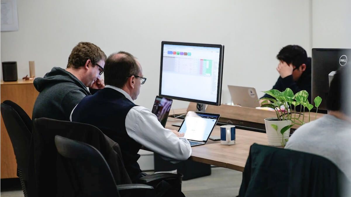 Two of Airteam's team members working on a software development project together at their desk in Sydney.