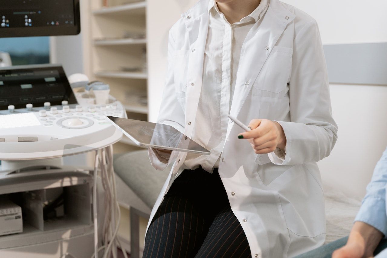 A medical professional with a patient holding an ipad and apple pen.