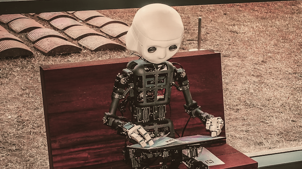 A humanoid robot working on a laptop