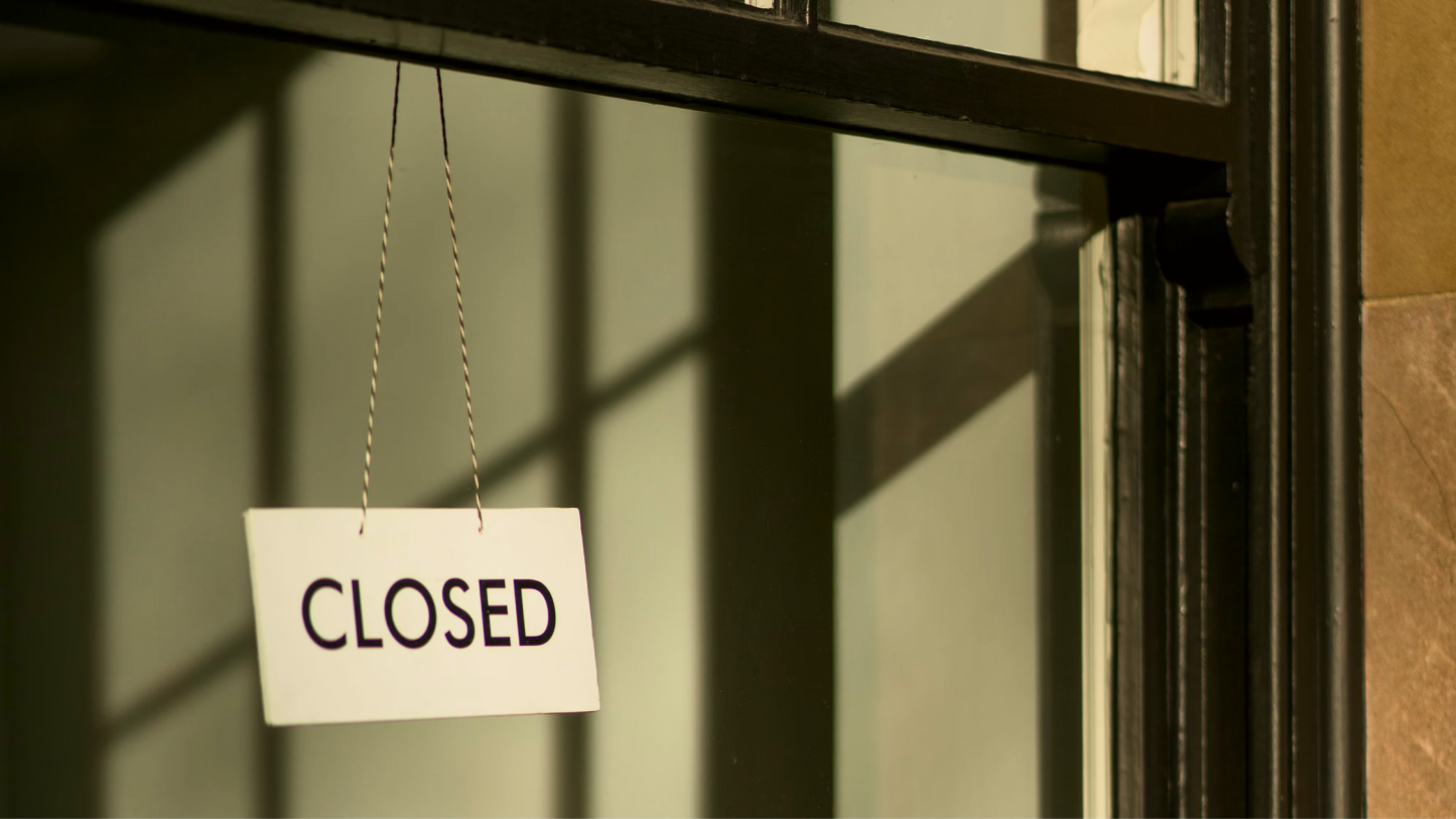 A closed sign hanging in a window