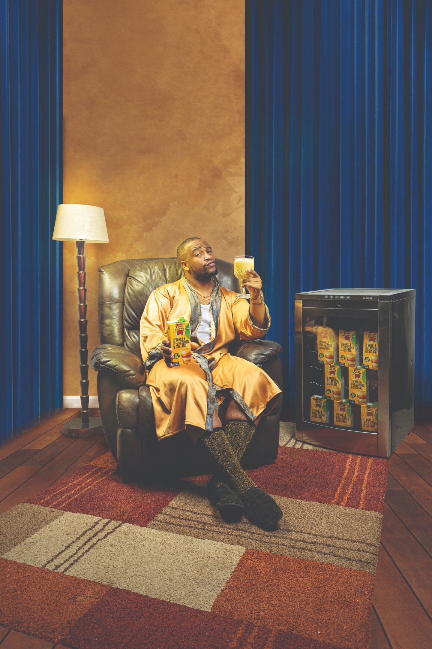man sitting on couch holding a glass of custard